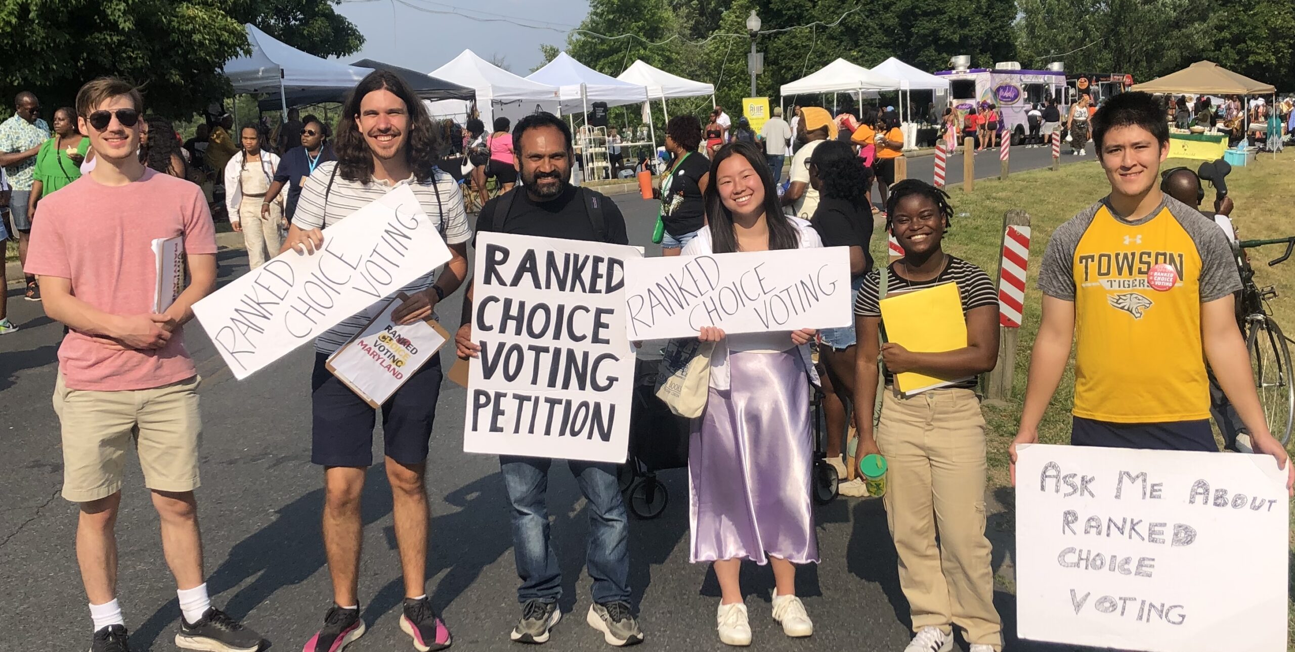 A group of volunteers holding signs at an event.